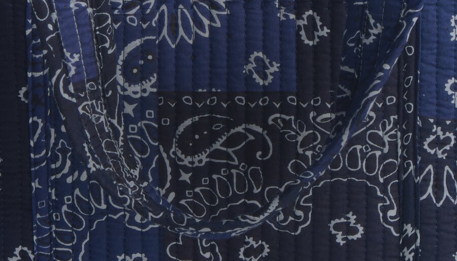 Close-up of navy quilted fabric featuring patchwork bandana-inspired prints.