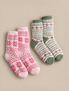 Two pairs of cozy patterned socks in pink and green with festive snowflake designs, arranged on a neutral beige background.