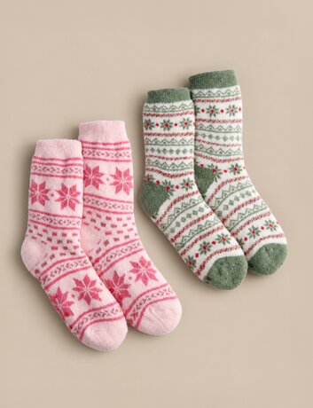 Two pairs of cozy patterned socks in pink and green with festive snowflake designs, arranged on a neutral beige background.