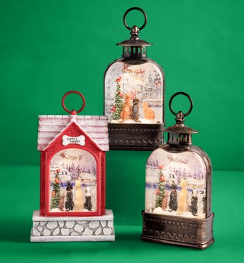 Three glitter lanterns lit up in front of a green background