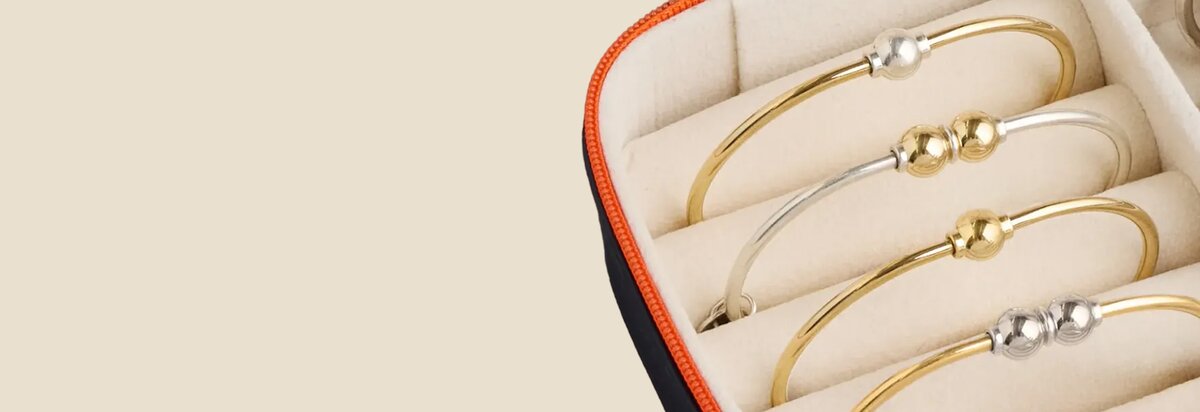 A jewelry box with Cape Cod Bracelets with gold bands and silver balls, and silver bands and gold balls