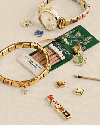 Gold-tone Italian charm bracelets displayed with colorful enamel and gemstone charms on a neutral background.