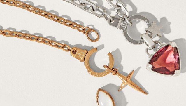 Image of Air & Anchor Cuff Keeper chains. Silver Chain has a red crystal charm and a silver star charm, gold chain has a gold cross charm.