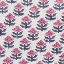 Close up of repeating hand-block–style floral pattern with pink blossoms and indigo leaves on a cream background, finished with subtle vertical quilting stitches.