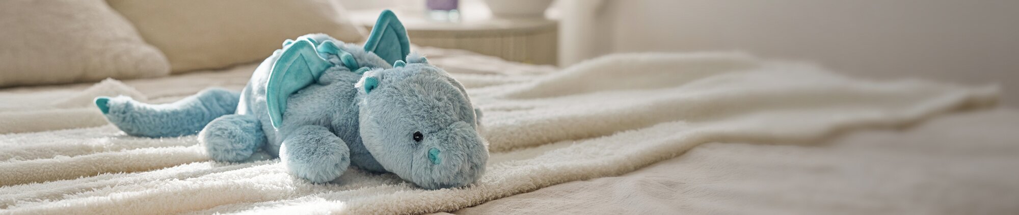 Image of Sapphire Laying Dragon Plush Toy on a plush blanket