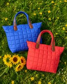 Blue and coral quilted tote bags on grass with sunflowers - $30
