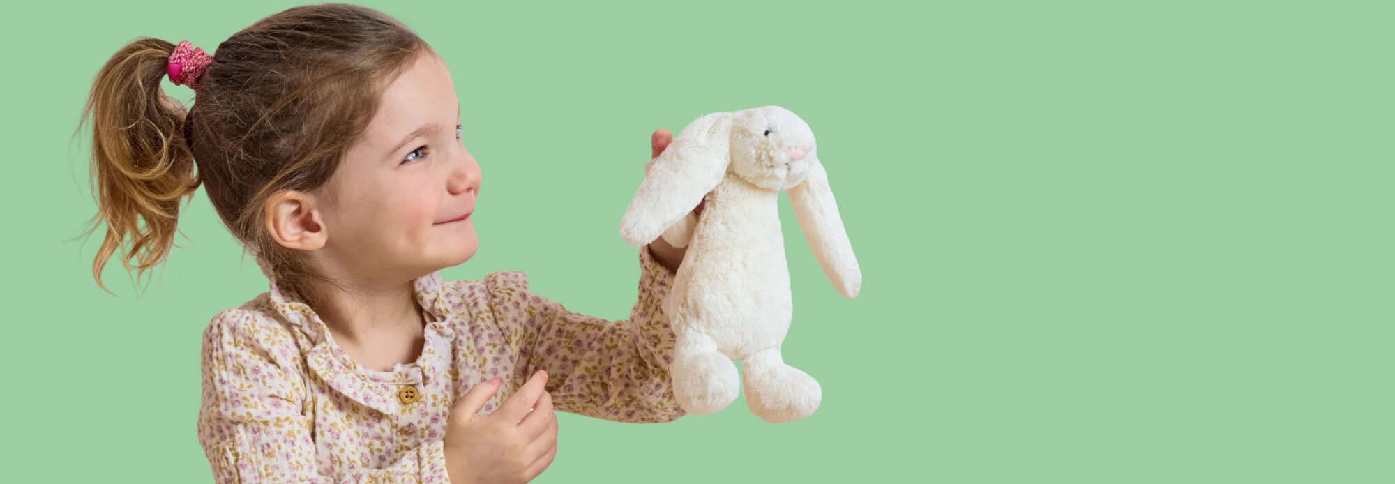 image of a young girl holding a white Jellycat bunny