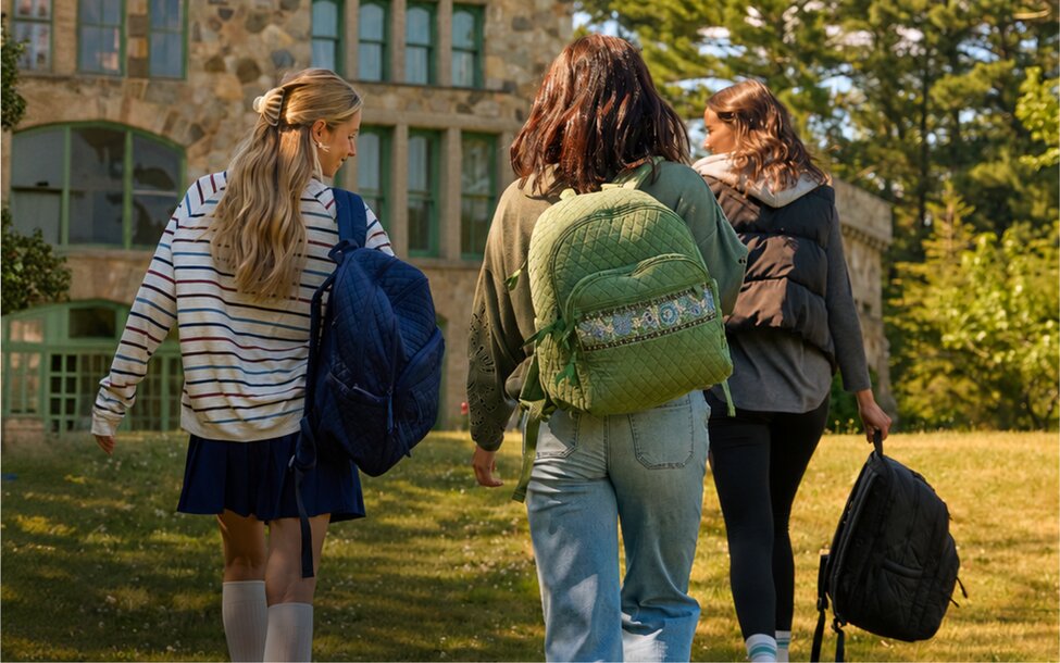Students walking across campus carrying backpacks. Shop backpacks.