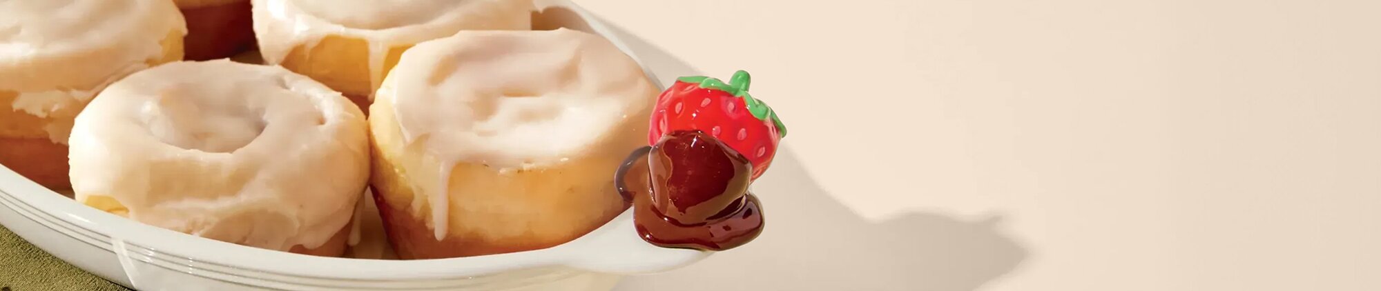 Image of cinnamon buns in a Nora Fleming Pinstripes Border Oval Ceramic Baker Dish with Sweet On You Chocolate Covered Strawberry mini Platter Ornament. 