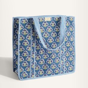 Image of Strawflower block print tote bags hanging from a rack with pink and blue patterns