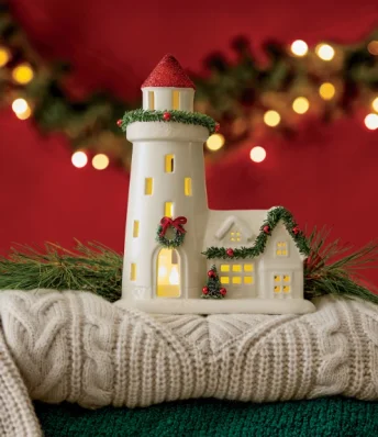 Image of Christmas home decor featuring a holiday lighthouse decorated with wreath and garland