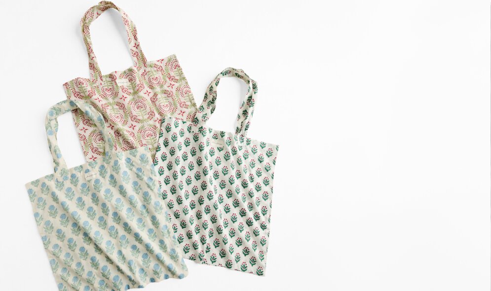Three reusable market totes featuring coordinating floral prints on a white background.