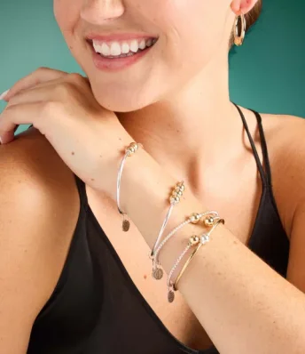 Close-up image of a woman wearing layered bracelets