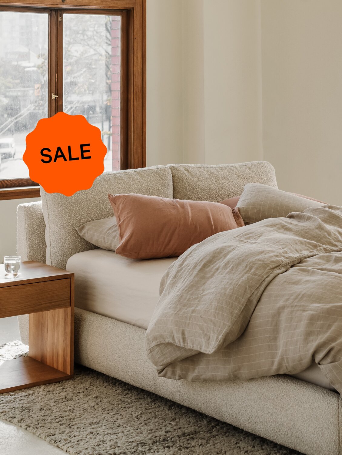 Cozy neutral bedroom with sale sticker overlay.