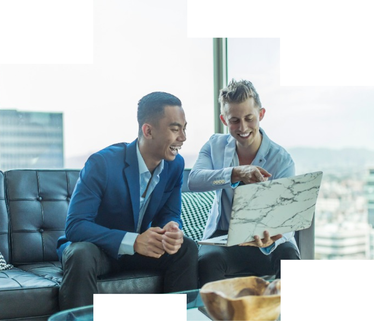 Two men smiling at a laptop
