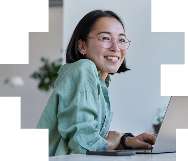 Woman in glasses working happily from her laptop