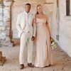 Groomsman wearing a tan suit and rose gold tie with bridesmaid in rose gold dress