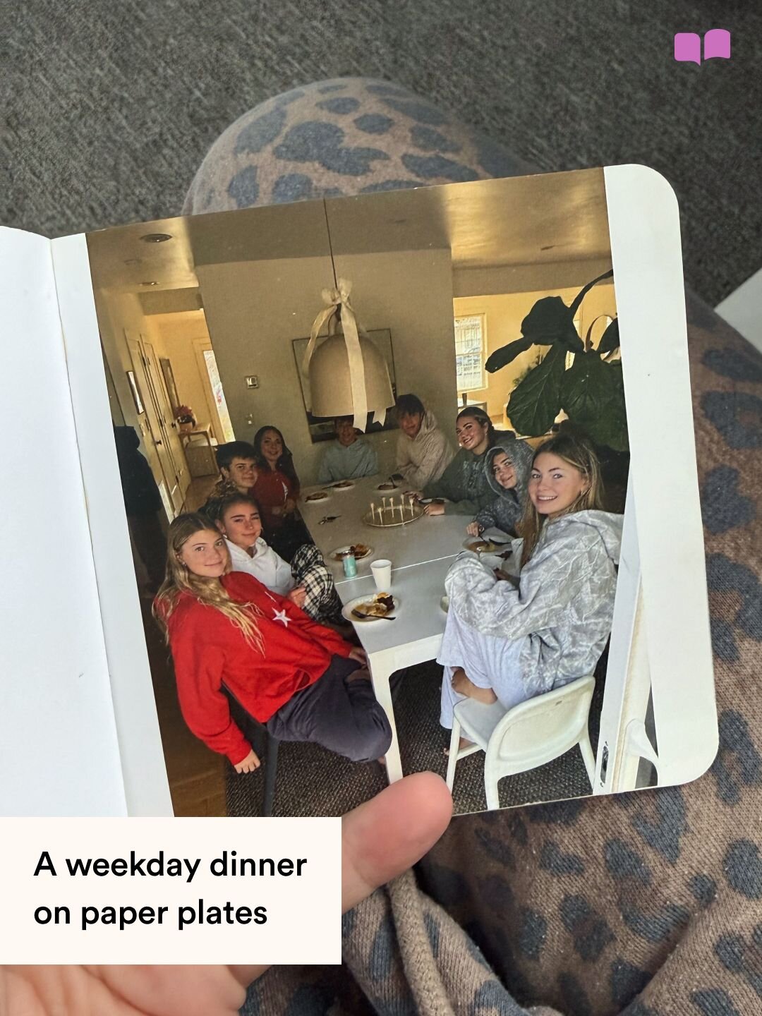 A Monthly Mini photo book page showing a family gathered around a dinner table, captioned A weekday dinner on paper plates