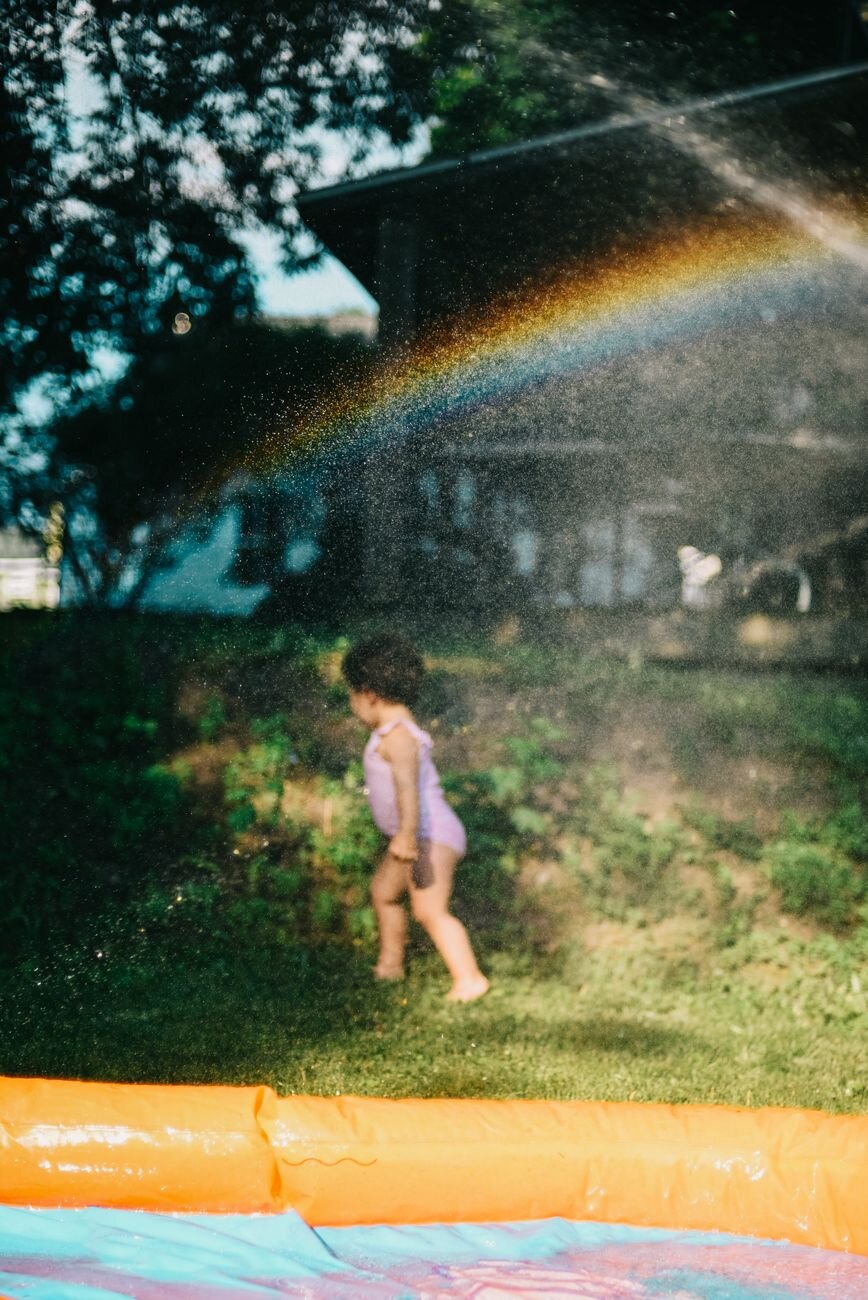 kid in sprinklers 