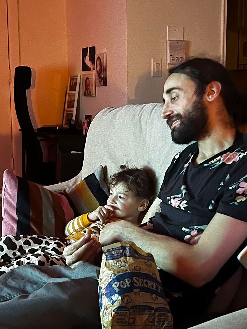 man and boy eating popcorn 