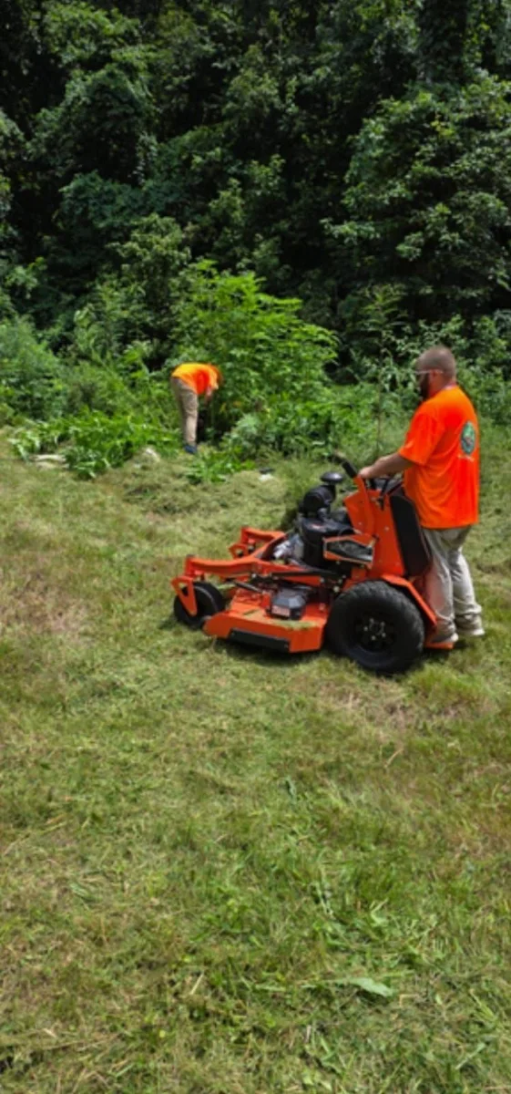 Elite Lawn Rangers crew member mowing crisp stripes on a zero-turn mower