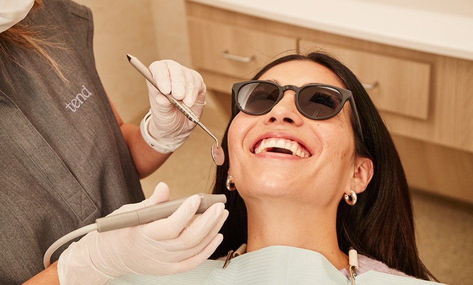 Woman smiling while getting teeth cleaned