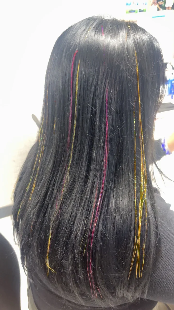 Colorful hair tinsel in dark hair