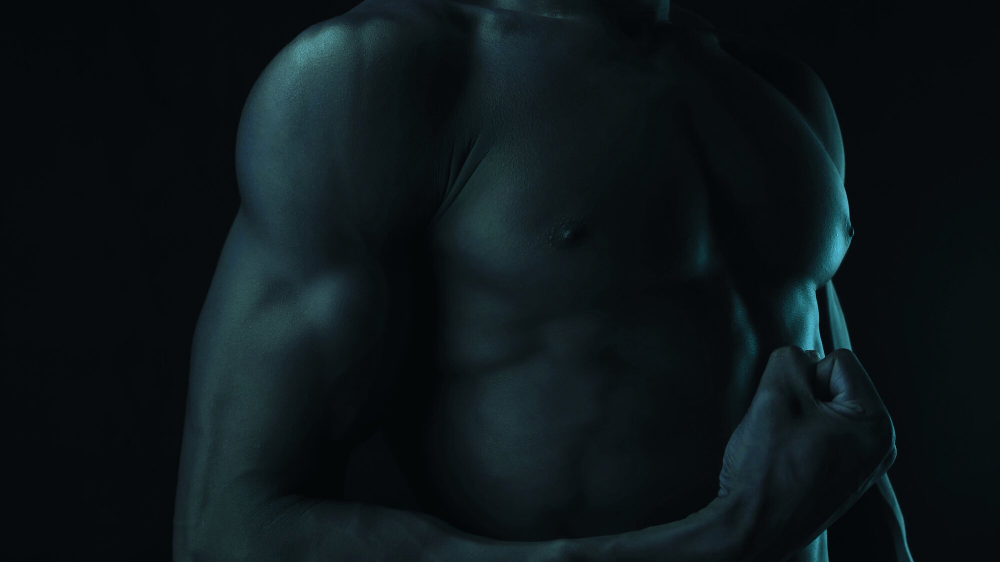 Muscular male torso flexing bicep – representing muscle growth and protein intake
