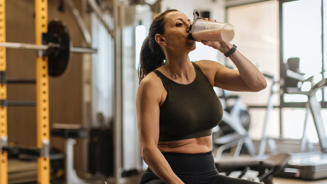 Fit couple discussing when to take protein shake before or after workout to support fitness and recovery goals.
