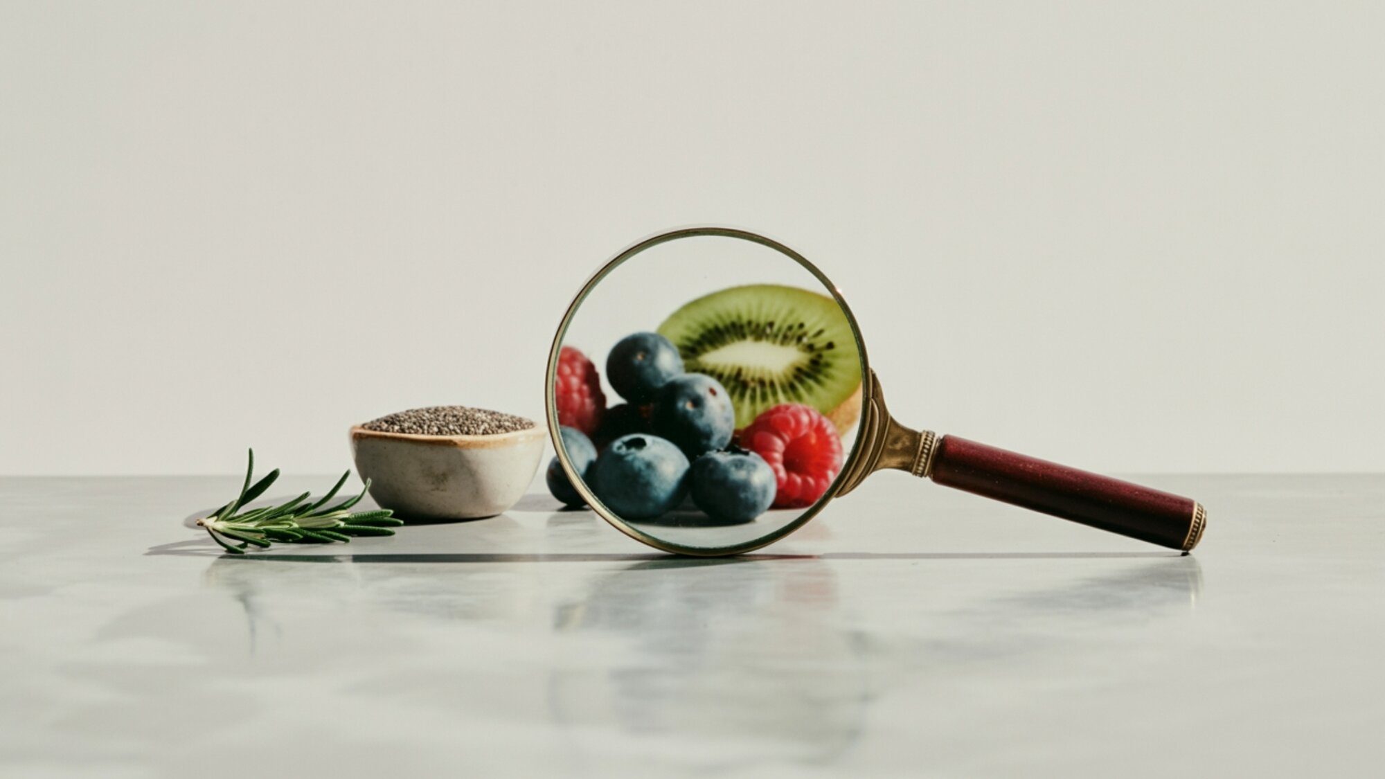 Magnifying glass focusing on fruits, seeds, and herbs, highlighting the importance of balancing macronutrients and micronutrients for good nutrition