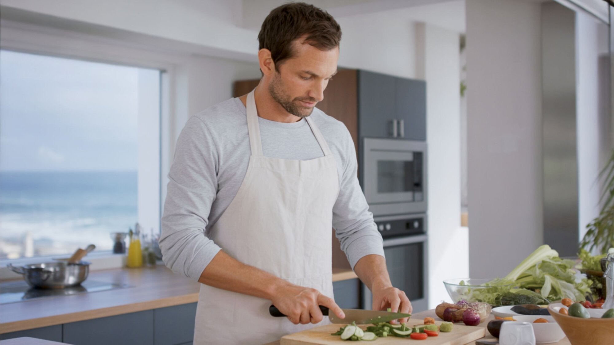 Chris preparing fresh vegetables in kitchen, simple meal ideas for a plant based diet for beginners.