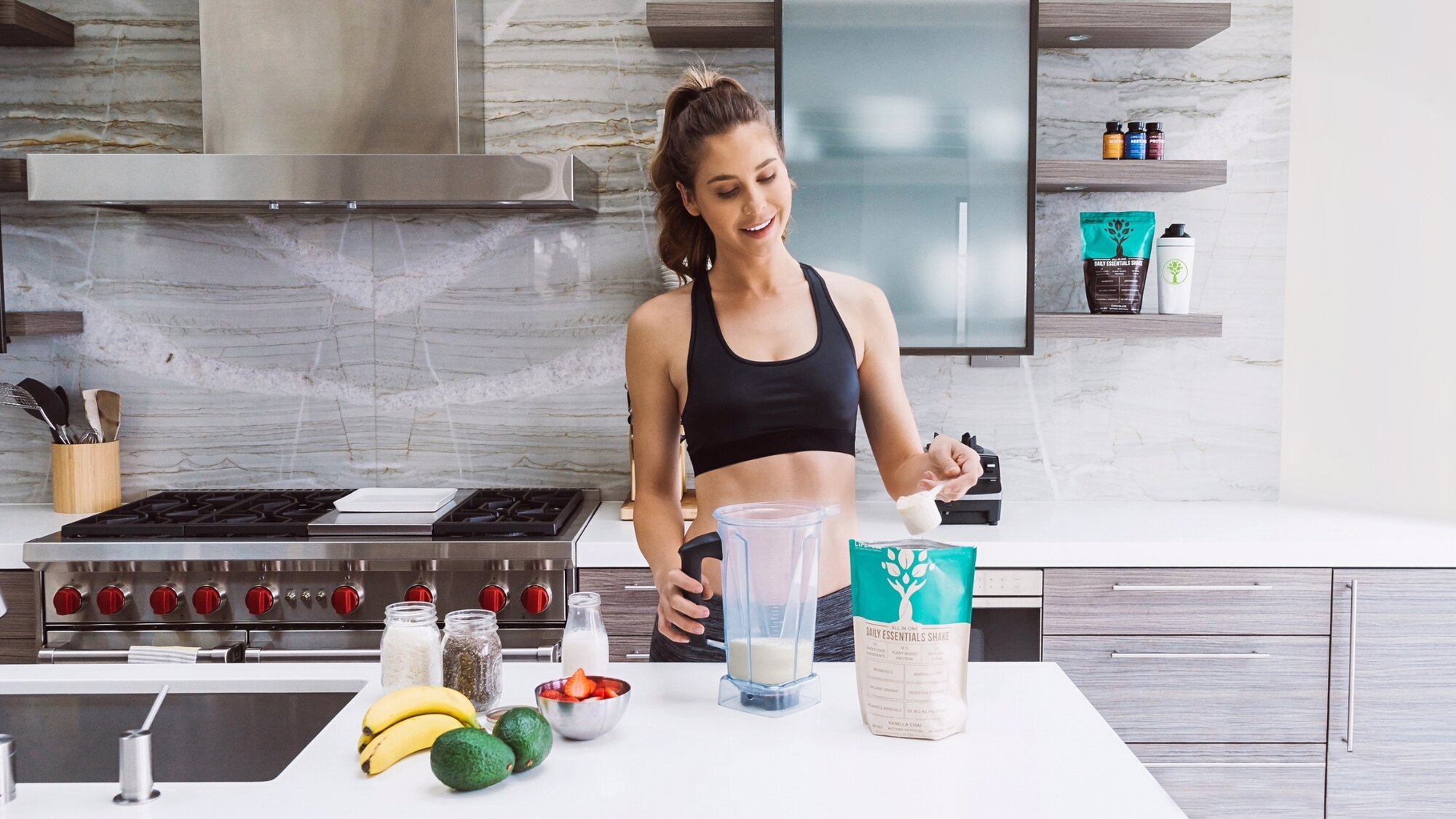 Woman making a meal replacement smoothie with LyfeFuel Essentials Shake using fresh ingredients.