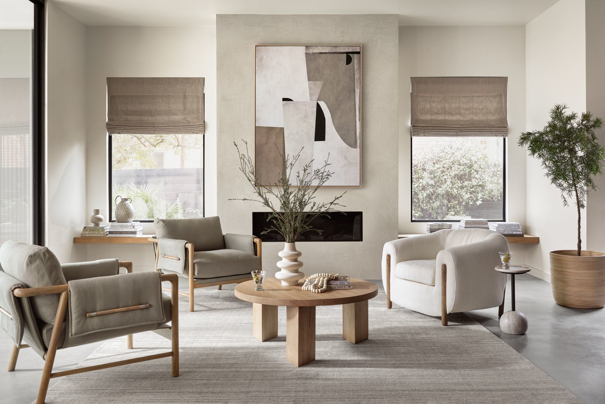 Living room scene featuring a spacious beige sectional, wood framed accent chair, and a black, square coffee table sitting on top of a traditional patterned rug.