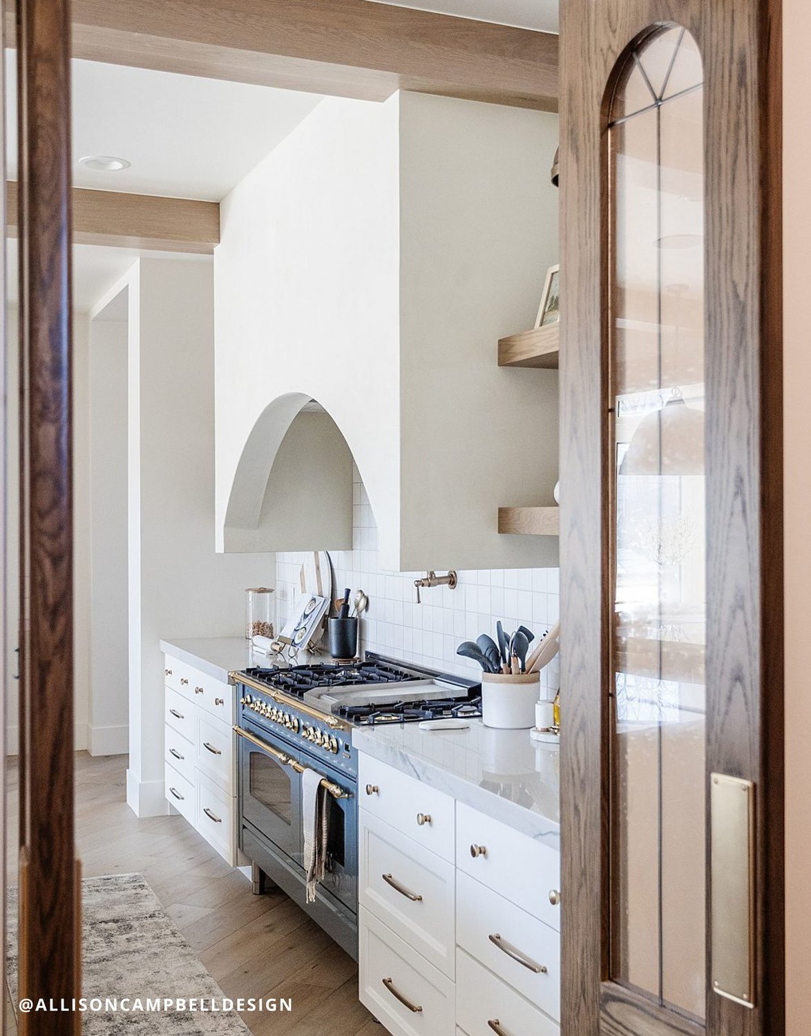 Rustic kitchen featuring wooden door and stove.