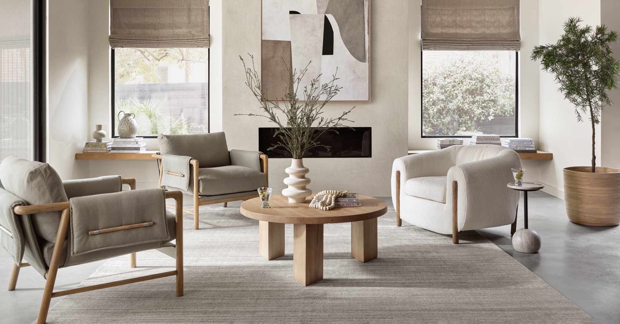 Living room scene featuring a spacious beige sectional, wood framed accent chair, and a black, square coffee table sitting on top of a traditional patterned rug.