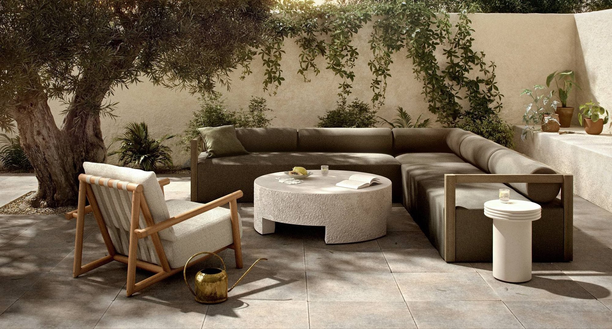 Sustainable outdoor upholstered sofa and armchair paired with stone coffee table arranged on a patio surrounded by trees.