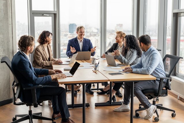 people around a boardroom-style table having a meeting