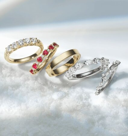 A group of 4 wedding bands surrounded by snow