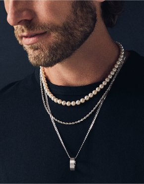 A man wearing a pearl necklace strand