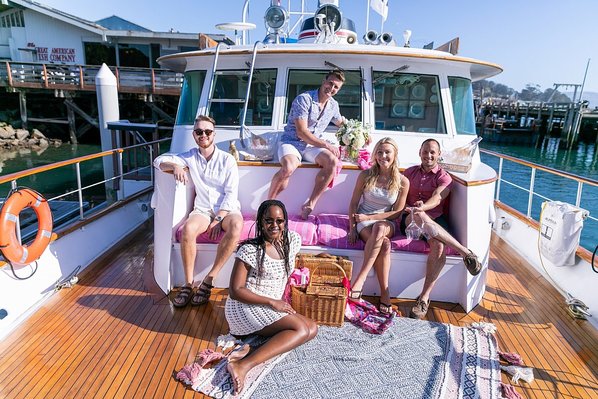 A group of friends wearing pink on a boat.