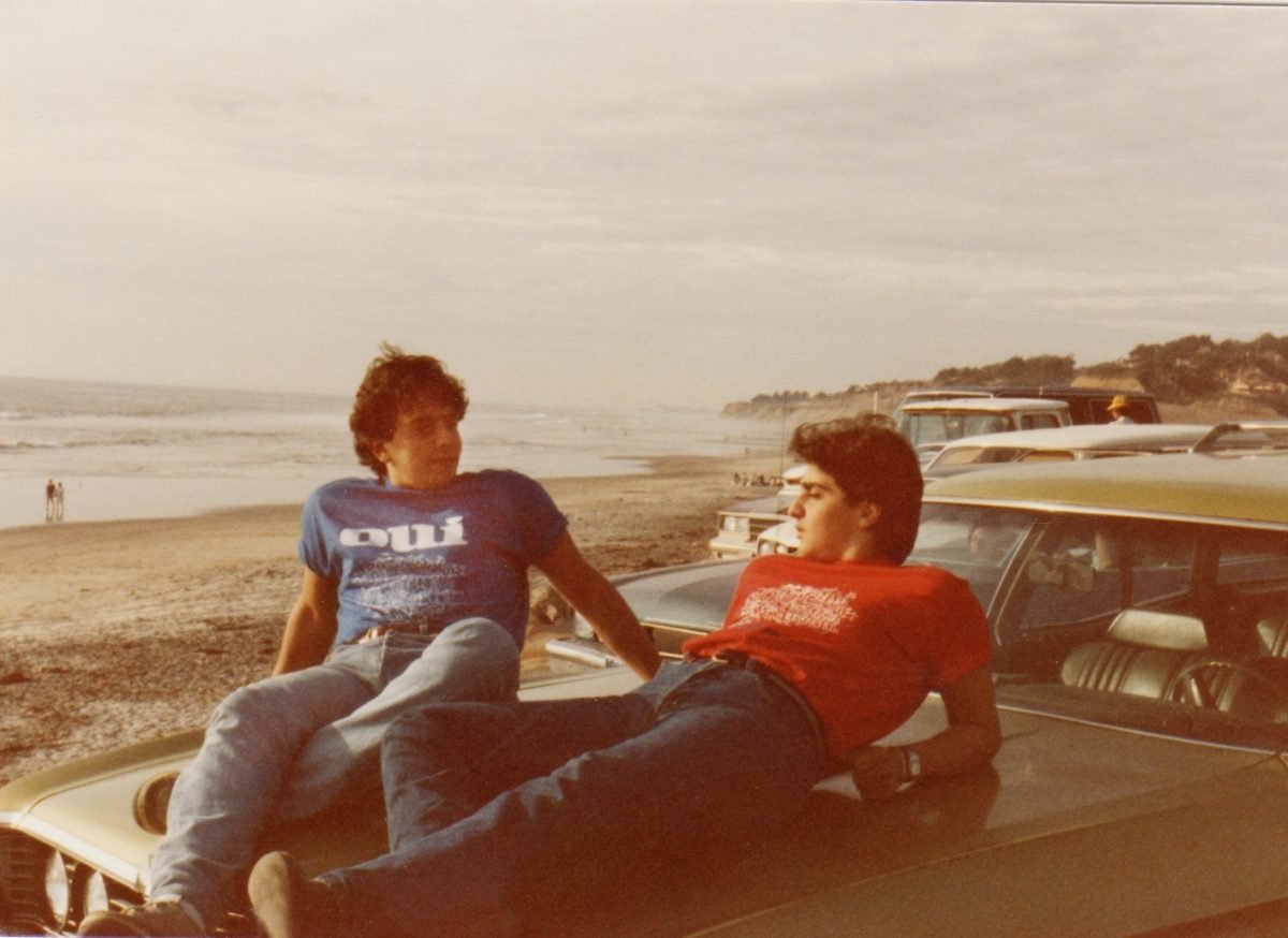 The Daou brothers at the beach, sitting on a car, in the 1970s