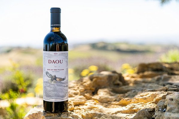 A bottle of Eye of the Falcon wine with rocks and mountains in the background