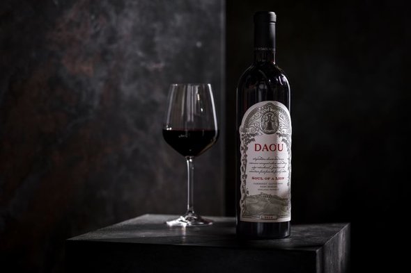 A bottle of 2019 Soul of a Lion next to a full glass of red wine