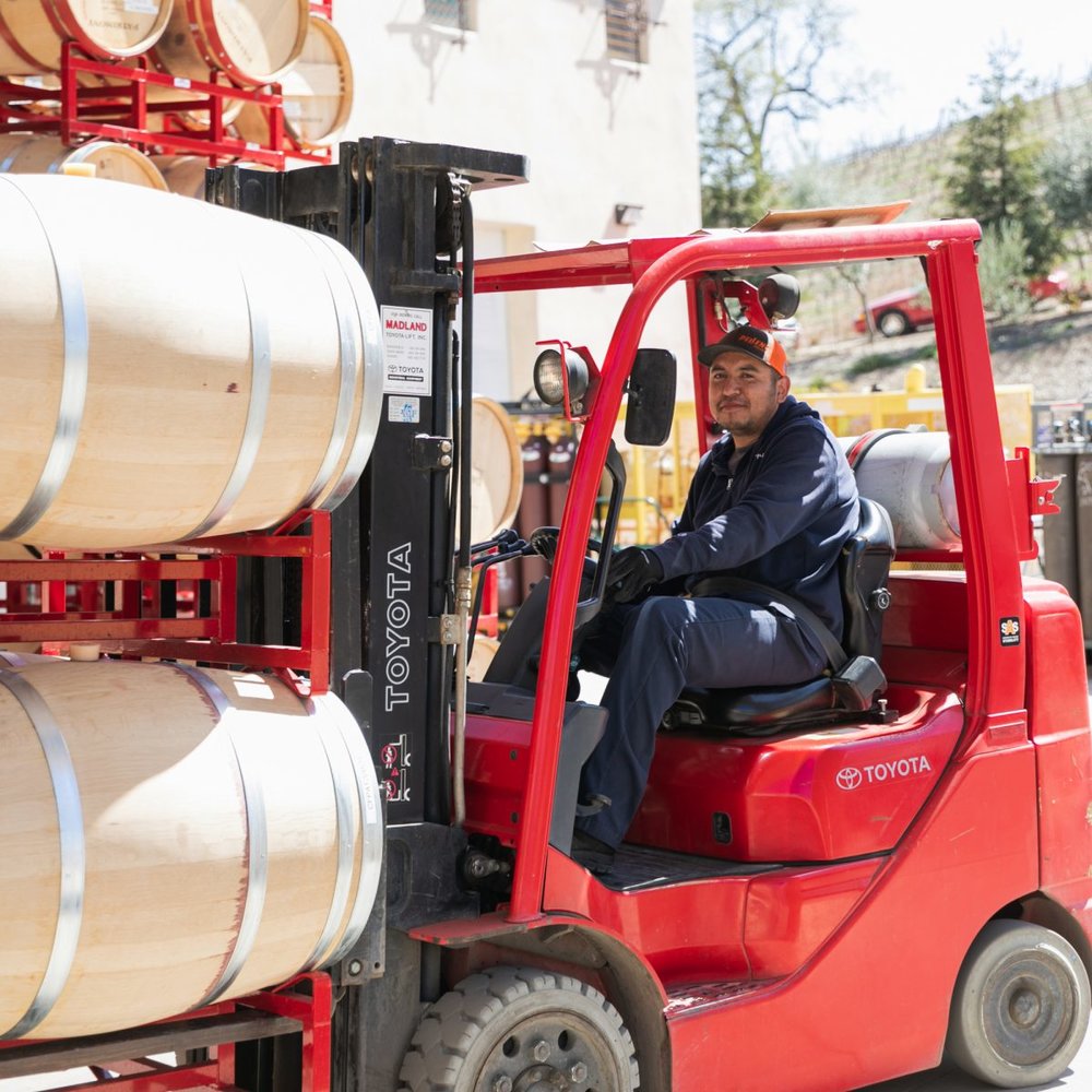 A forklift is used to transport wine barrels