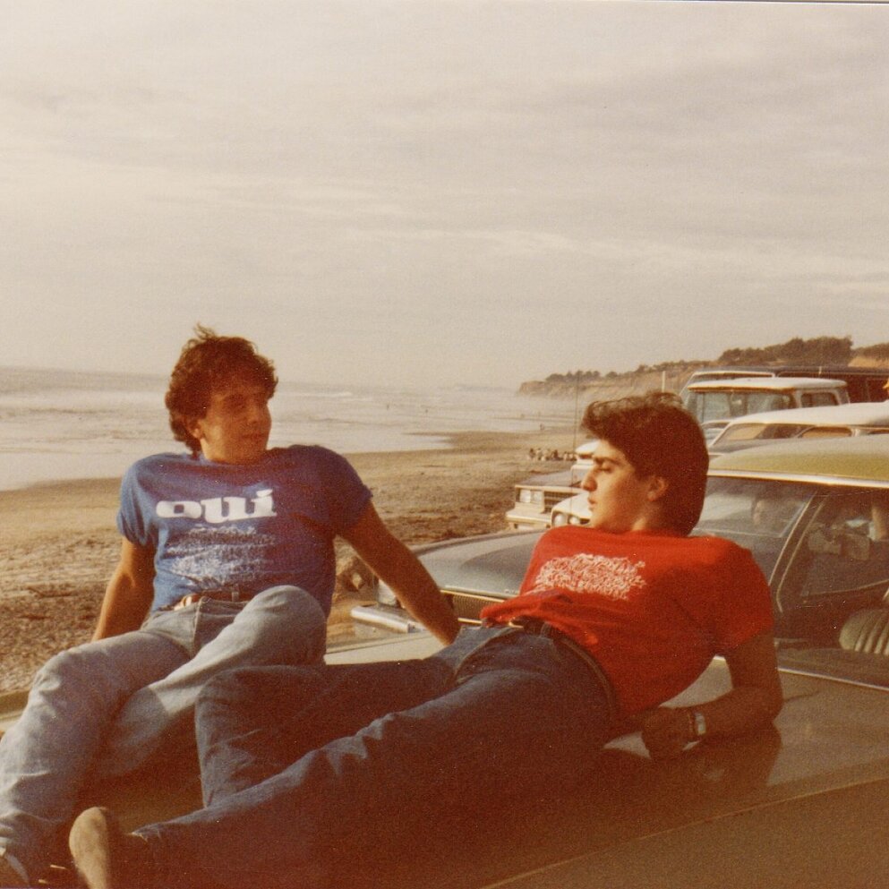 Georges and Daniel Daou at the beach sitting on a car in the 1970s