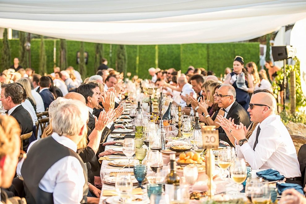 A big gathering at a long decorated table