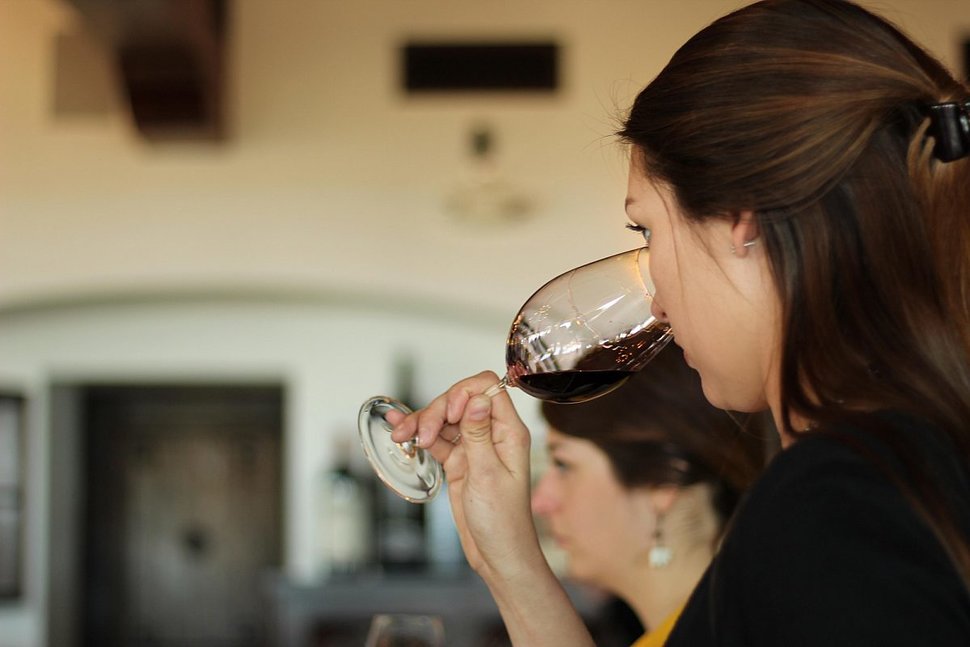 A woman smells a wine in a glass
