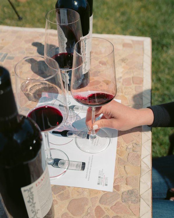 A hand is pouring a Chardonnay into a glass on a decorated table