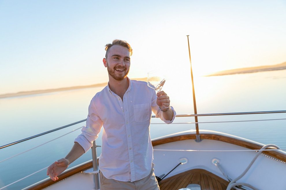 A man on a boat with a glass of rosé
