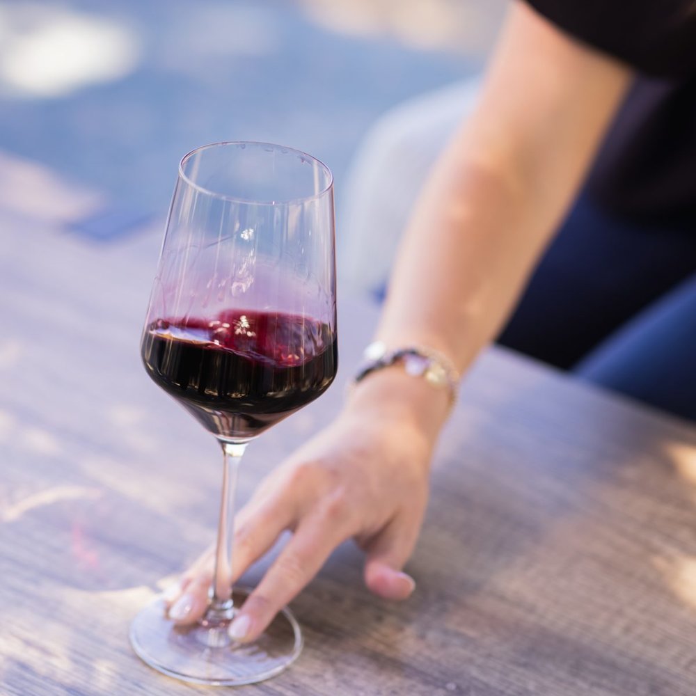 A hand swirls a glass of red wine